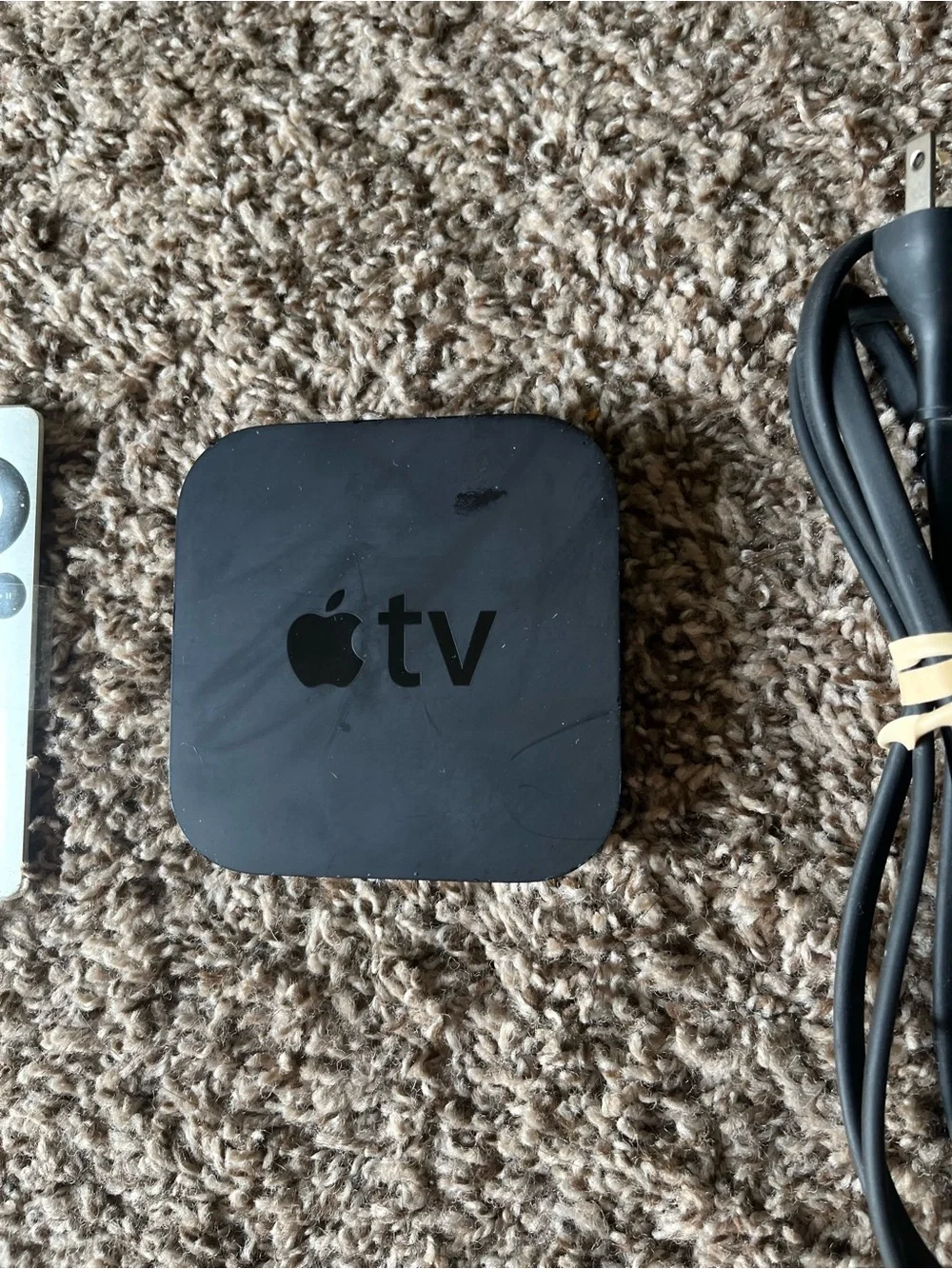 Apple TV with Silver Remote and Black Power Cable
